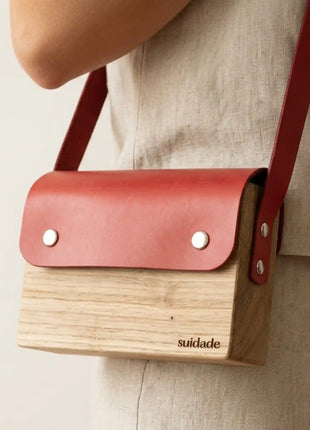 Bolso de madera Forxa con cuero vegetal rojo en bandolera sobre look natural, regalo unico para mujer fabricado en Espana