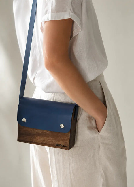 Bolso de madera Tina con cuero vegetal azul en bandolera sobre look casual, regalo original para mujer hecho a mano en Galicia