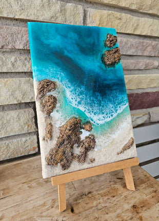 Cuadro de resina Playa de Barrika con rocas y mar turquesa hecho a mano en Bizkaia, vista frontal sobre caballete