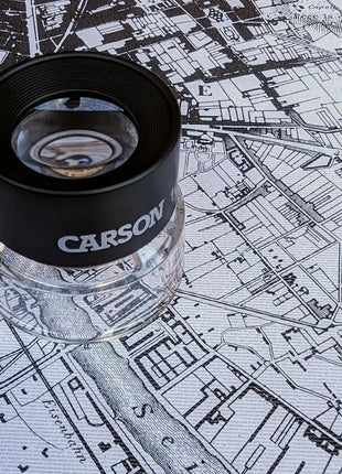 Lupa Carson sobre la lámina Historia de Dos Ciudades con plano de París