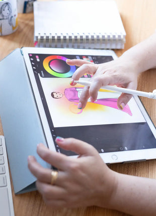 Itxaso Goitia trabajando en su estudio creando una ilustracion personalizada hecha a mano, con tablet y materiales de dibujo