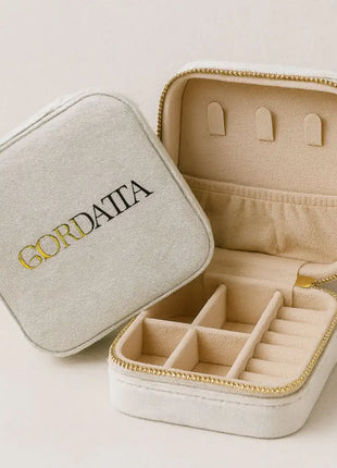 Joyero de viaje Qordatta aterciopelado blanco abierto, con compartimentos para anillos, pendientes y cadenas, cierre dorado