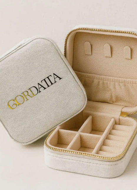 Joyero de viaje Qordatta aterciopelado blanco abierto, con compartimentos para anillos, pendientes y cadenas, cierre dorado