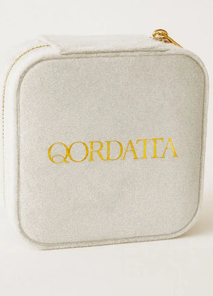 Joyero de viaje Qordatta aterciopelado blanco cerrado con logo dorado bordado y cierre de cremallera dorada