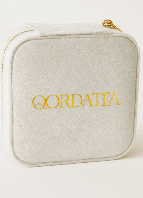 Joyero de viaje Qordatta aterciopelado blanco cerrado con logo dorado bordado y cierre de cremallera dorada