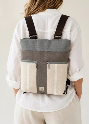 Mujer con Mochila Sullana lisa hecha a mano en Bilbao con tejido natural y rayas gris topo, regalo original para mujer unico e irrepetible