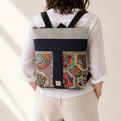 Mujer con Mochila Sullana estampada hecha a mano en Bilbao con tejido de mandalas multicolor en tonos ocre y verde, regalo original para mujer unico e irrepetible