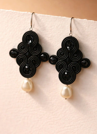 Pendientes Dona Macarena de soutache negro con cristales y perla natural hechos a mano en Bizkaia, sobre base blanca