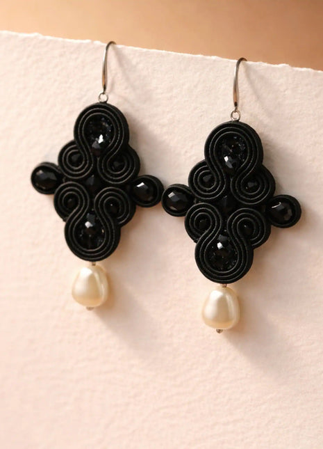 Pendientes Dona Macarena de soutache negro con cristales y perla natural hechos a mano en Bizkaia, sobre base blanca