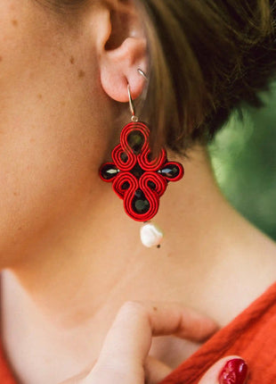Mujer con pendientes Dona Macarena de soutache rojo y perla hechos a mano en Bizkaia, regalo original para mujer unico e irrepetible