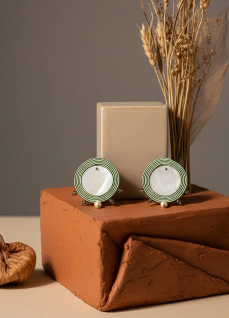 Pendientes Trianita de nacar y soutache verde hechos a mano en Bizkaia, con perla natural, sobre bodegon terracota