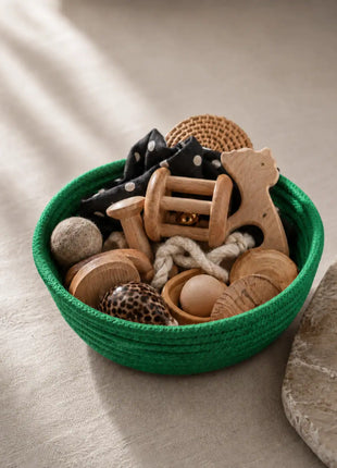Cesta Tesoros Natura Montessori en color verde con juguetes sensoriales de materiales naturales — regalo original para bebé