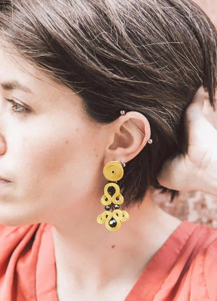 Mujer con pendientes Versalles de soutache amarillo hechos a mano en Bizkaia, regalo original para mujer unico e irrepetible